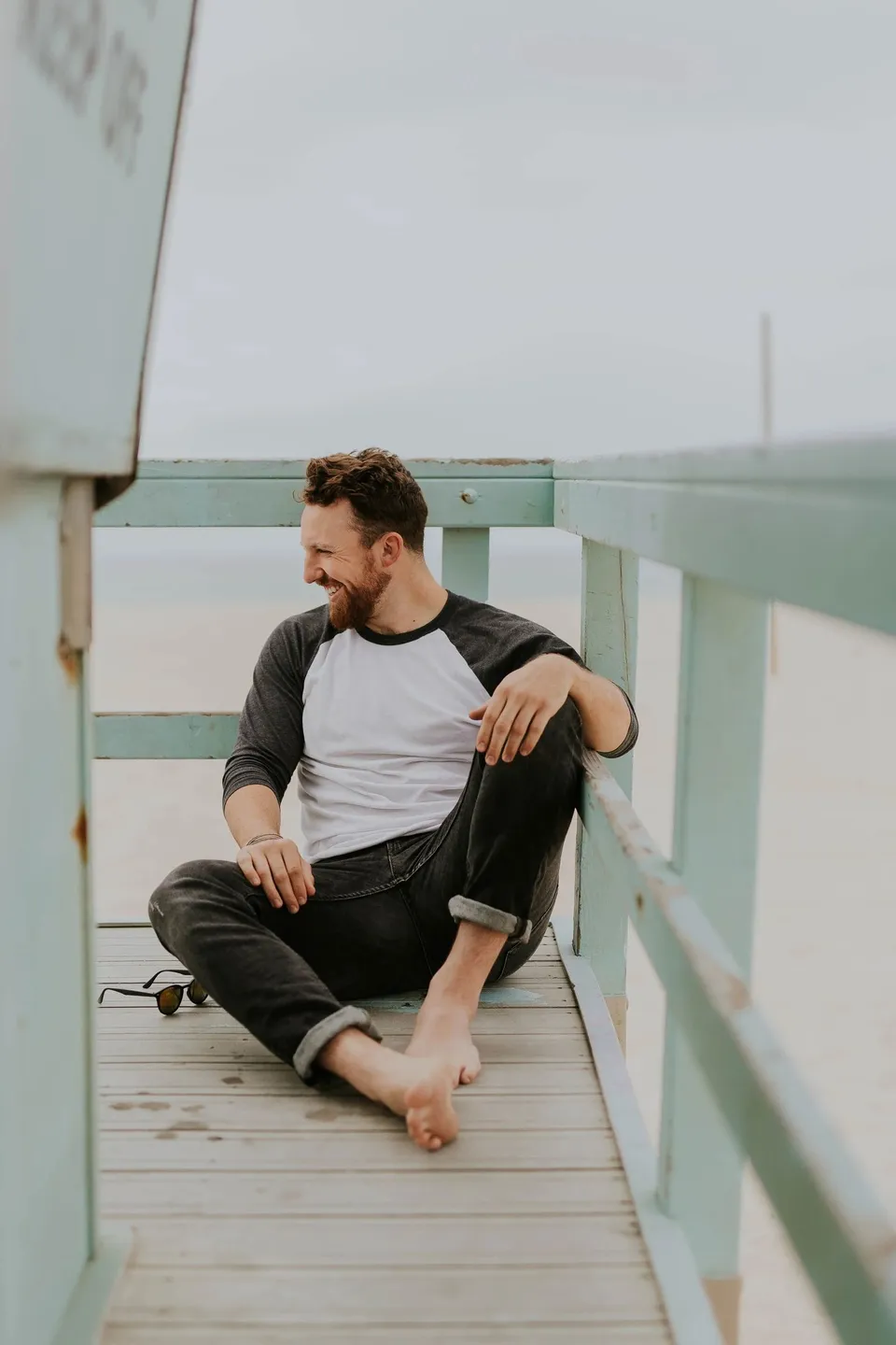 A man relaxing on a lifeguard tower by the beach